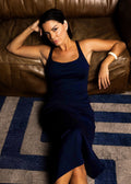 Lifestyle image model sitting on floor wearing a navy midi bodycon dress